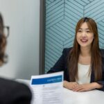 Jeune femme souriante en blouse lors d'un entretien d'embauche